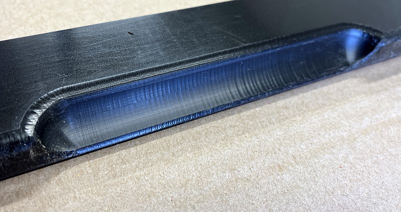 Close-up of a chamfered slot machined in black HDPE
